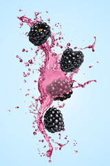 Fresh blackberries and juice in air on light blue background