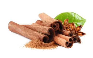 Rolgordijnen Aromatic cinnamon sticks, powder, anise stars and green leaf on white background, banner design © New Africa