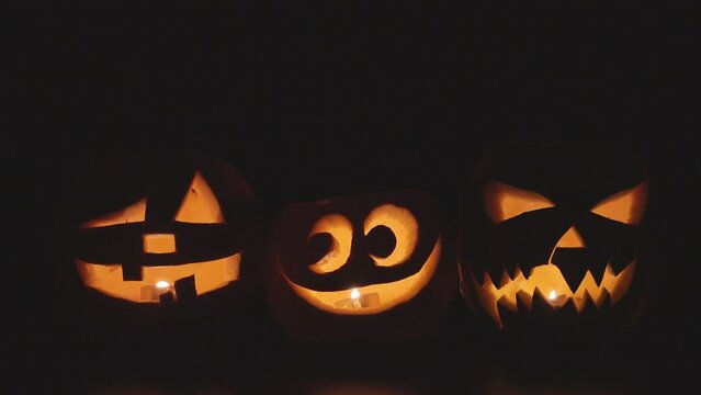 Halloween jack-o'-lantern in a yellow pumpkins lighting in the dark