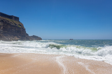 North Beach famous for giant waves in Nazare town on so called Silver Coast, Oeste region of Portugal, view with fort of Saint Michael the Archangel