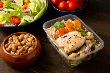 Healthy Fitness chicken and rice packed lunchbox meal in wood background in front top view