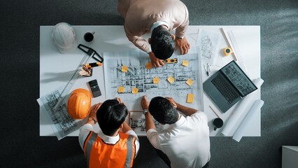 Top down aerial view of smart architect engineer team pointing and discussing about building...