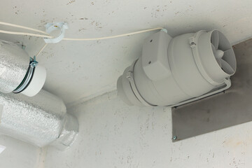 Electric water heater installed overhead with ducting