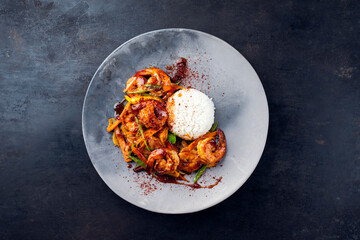 Traditional Thai fried king prawns with vegetable, mango and rice served as top view on a design plate with text space