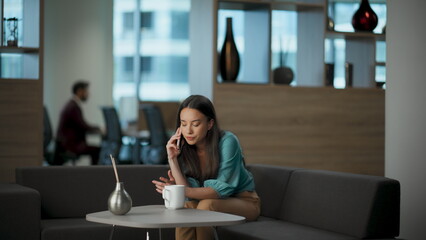 Busy woman employee calling cell sitting office alone. Businesswoman talking