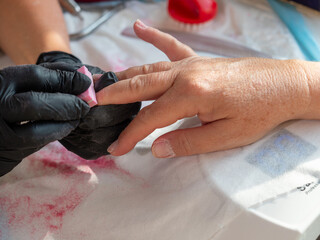 Manicure woman using polishing sponge removing old polish for permanent nail paint
