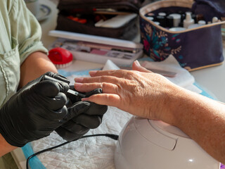 Manicure woman applying cuticle oil after removing old polish for permanent nail paint