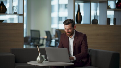 Fototapeta premium Happy worker looking computer in cozy office. Businessman rejoicing success