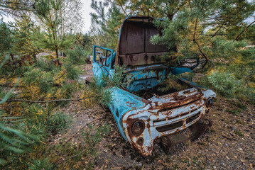 Fototapeta na wymiar Old car on wrecking yard near Illinci village in Chernobyl Exclusion Zone in Ukraine