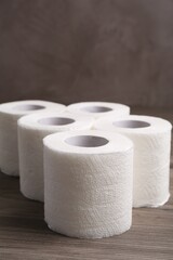 Soft toilet paper rolls on wooden table, closeup