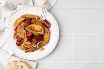 Delicious baked potato with thin dry smoked sausages and onion served on white tiled table, flat lay. Space for text