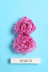 International Women's day. 8th of March made with beautiful peonies on light blue background, top view