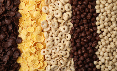 Different types of breakfast cereals as background, top view