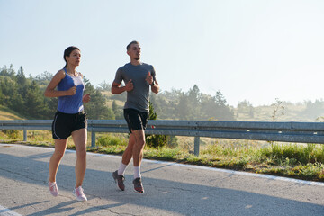 Energized by the beauty of nature, a couple powers through their morning run, their bodies and...