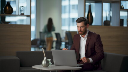 Aggressive guy watching computer at coworking room. Businessman feeling furious