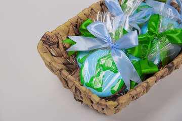 A basket filled with cookies in shape of Earth on green backdrop. Earth Day concept. - 757599359