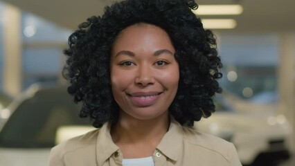 Portrait girl African American ethnic woman joyful satisfied customer buyer in auto showroom female owner new luxury automobile rent car service in dealership store buy transport happy client smile