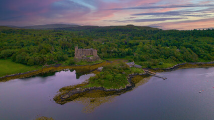 Fototapeta na wymiar AERIAL: Medieval Dunvegan Castle built on an elevated rock overlooking sea loch