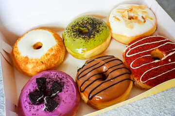 Assorted donuts in paper box, looks sweet and delicious