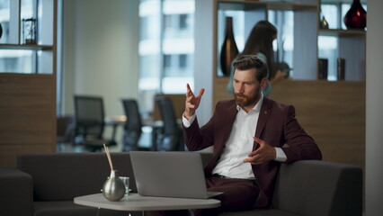 Stressed man confused mistake documents looking laptop at office. Guy gesturing