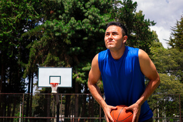 Man training basketball in court in sunny day at summer 