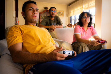 Friends playing video games with video game controllers in living room at home 