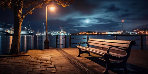 Fotobehang A bench by the harbour in the evening with dramatic light © britaseifert