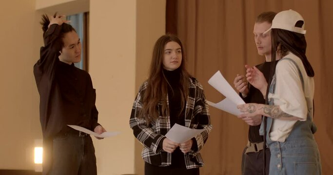 Young people discussing papers, possibly collaborating on a project, preparing a presentation, or studying educational material. Analyzing and understanding the text of script. Studying the dialogue.