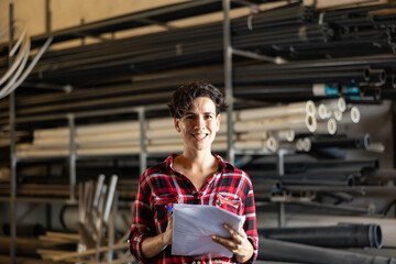 Cheerful latin woman making stock control, verifying documents while working warehouse.