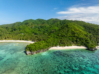 Cobrador Island with green trees and white sand beach. Romblon, Philippines.