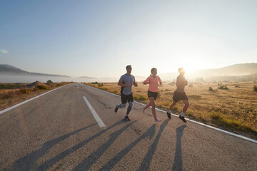 A group of friends, athletes, and joggers embrace the early morning hours as they run through the...
