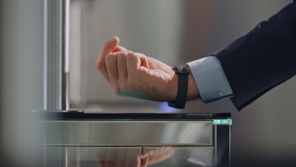 Hand smartwatch touching sensor control panel unlocking office turnstile closeup