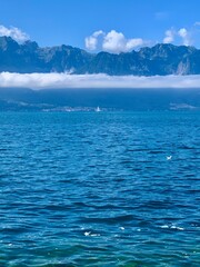 sea and sky. Sailboat. Lake and mountains. Clear alpine lake. Stone, rocks. Low clouds just above the water on a summer sunny day.