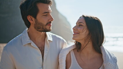 Smiling lovers walking seashore sunny day close up. Couple feeling love at coast