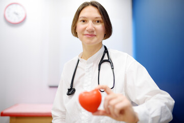 Female cardiologist holding red heart. Cardiology concept.