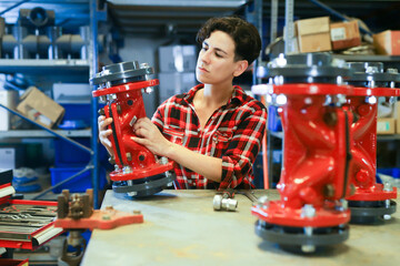 Latin woman mechanic assembling plumbing fixture in workshop. Skillful woman working in repair...