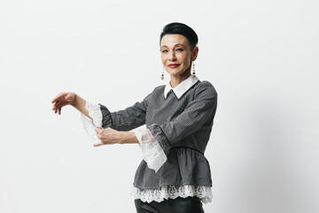 Young woman in stylish black leather pants and gray shirt gesturing with hands in expressive manner