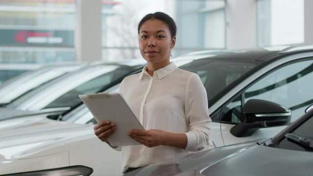 African American ethnic woman saleswoman seller consultant dealer car agent help to choose automobile in dealership store smiling happy girl looking at camera professional sales manager in showroom