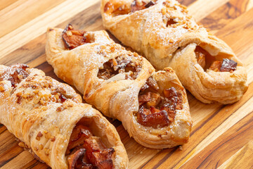 A Delicated Powder Sugar Dusted Apple Danish on a Wooden Table