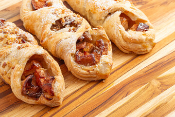 A Delicated Powder Sugar Dusted Apple Danish on a Wooden Table