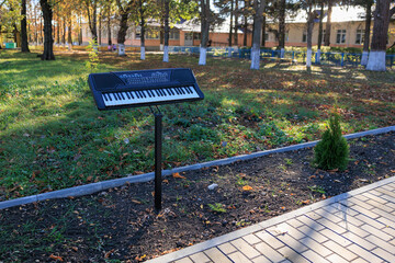A keyboard is on a stand in a park