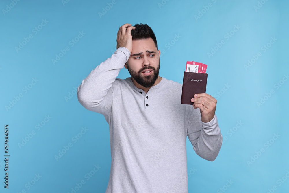 Wall mural emotional man with passport and tickets on light blue background