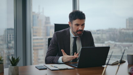 Fototapeta premium Nervous boss talking video meeting sitting office closeup. Manager videocalling 