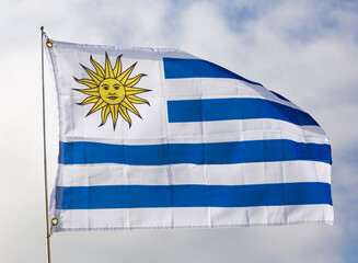 Uruguayan flag flies proudly in wind against blue sky