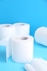 Soft toilet paper rolls on light blue background