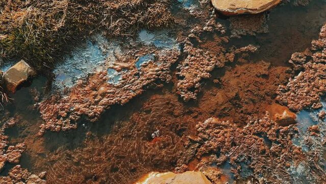 Narzan drinking spring in Ossetia. The bubbling water of a natural mineral spring against the background of a red rocky bottom. The healing water of the Narzan Valley. North Caucasus, Russia. 4K