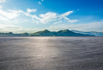 Deurstickers Asphalt road square and green mountain with sky clouds natural landscape at sunrise © ABCDstock