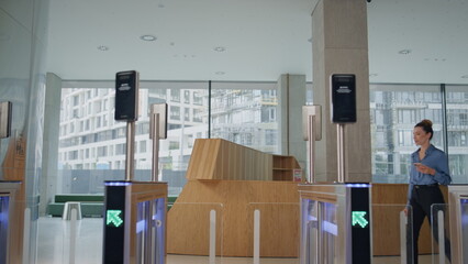 Businesswoman passing identification control walking automatic turnstile office 