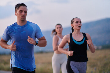 A diverse group of runners trains together at sunset.