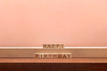 木目の段の上に誕生日の英語ブロックを並べたピンクの背景 - obrazy, fototapety, plakaty